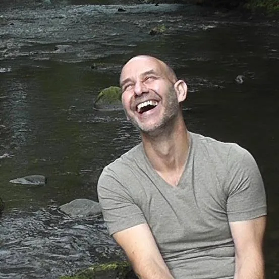 Colin Ellis laughing beside a river